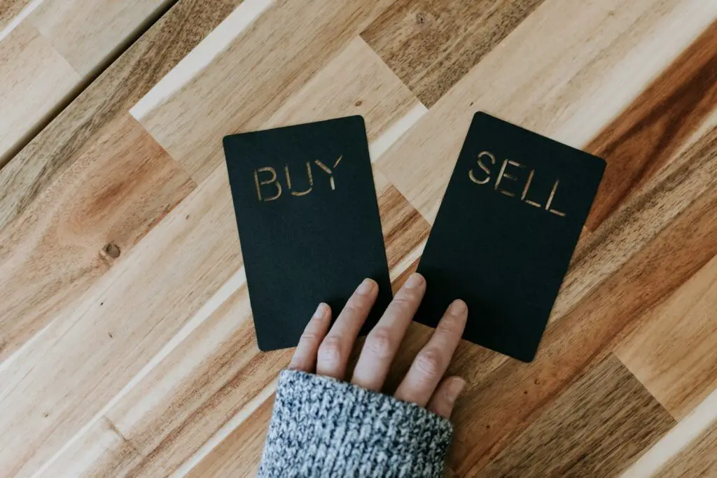futures trading - a person holding two small black books with the words buy and sell on them