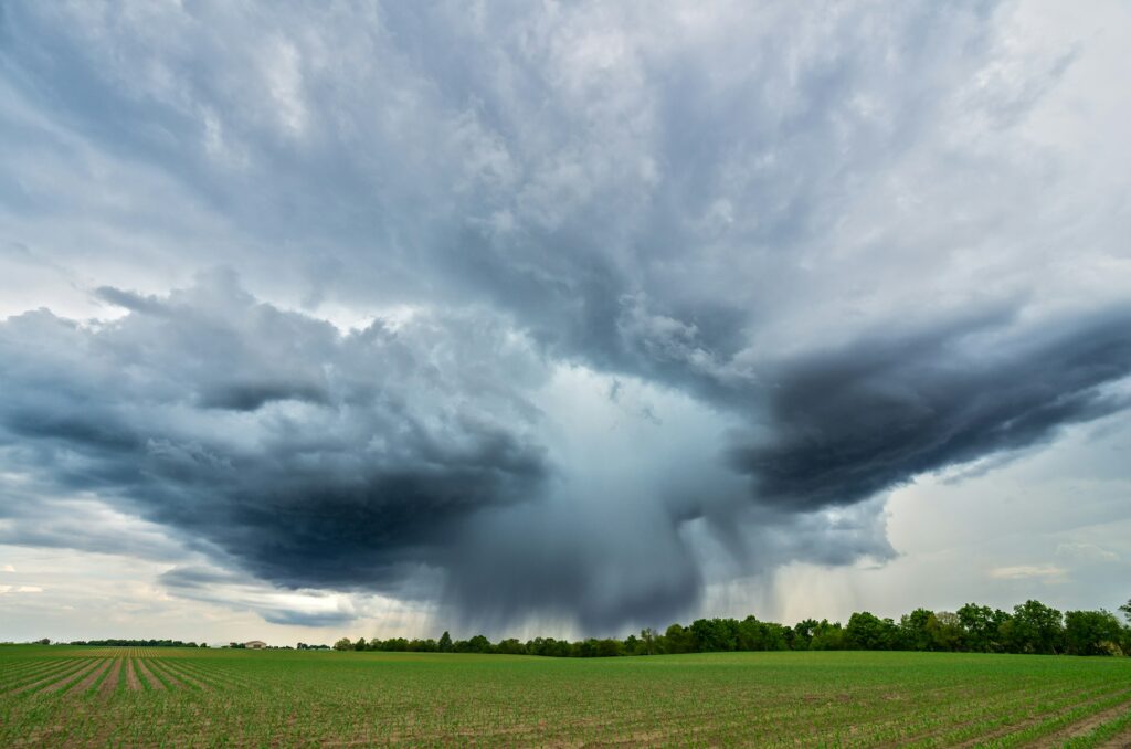 Dramatic storm clouds over green field