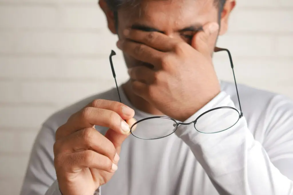 a man holding glasses to his face