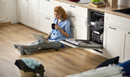 a woman sitting on the floor with a laptop and a cup of coffee