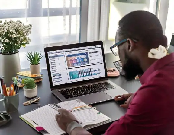 a man sitting at a desk with a laptop