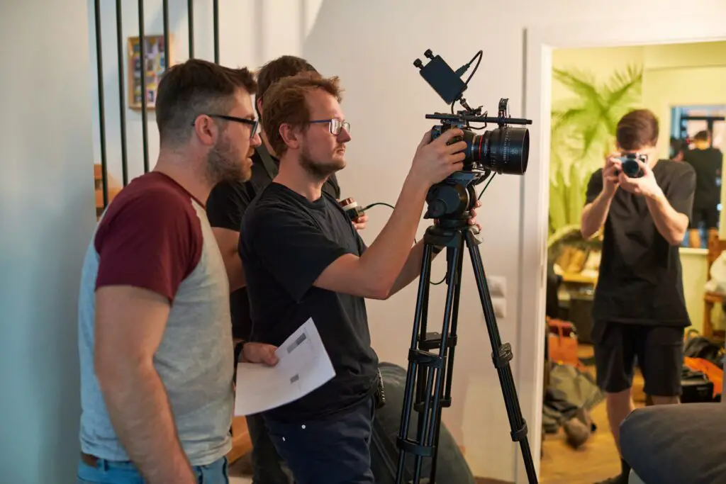 a group of men standing next to a camera